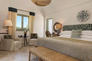 a bedroom with a king sized bed and a chair at Rocco Forte Masseria Torre Maizza in Savelletri di Fasano