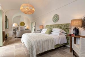 a bedroom with a bed and a living room at Rocco Forte Masseria Torre Maizza in Savelletri di Fasano
