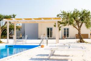a villa with a swimming pool with a table next to it at Isola dei poeti in Marzamemi