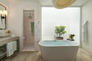 a large bathroom with a tub and a shower at Rocco Forte Masseria Torre Maizza in Savelletri di Fasano