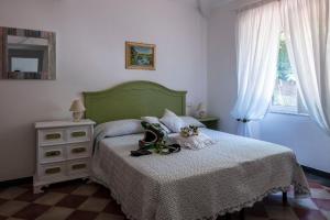 a bedroom with a green bed with a dresser and a window at La BRIGNA B&B Il bosco sul mare in Genoa