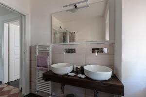 a bathroom with two white sinks and a mirror at La BRIGNA B&B Il bosco sul mare in Genoa