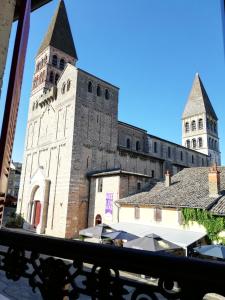 a large building with a clock tower in a city at LA MAISON DE MARION in Tournus