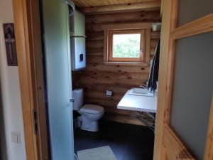 Un baño con inodoro, lavabo y ventana. en Brīvdienu mājiņas Zemzari, en Jūrkalne
