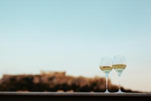 two glasses of wine on a table with a view at 360Degrees Pop Art Hotel in Athens