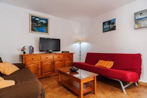 - un salon avec un canapé rouge et une télévision dans l'établissement Casa Miramundo, à Vejer de la Frontera