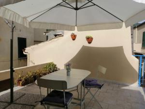 a table and chairs under an umbrella on a patio at Casa Mancusa in Badolato
