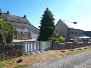een huis met een blauw hek naast een weg bij Gite Bleu Brittany near Dinan in Plumaudan