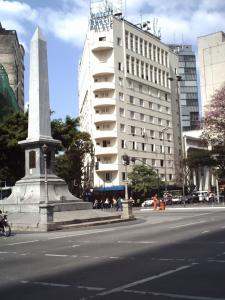 un monumento in mezzo a una strada con un edificio di Brasil Palace Hotel a Belo Horizonte