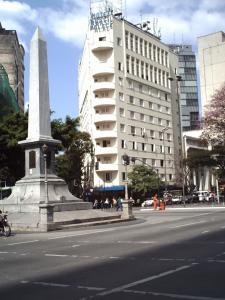 um monumento no meio de uma rua com um edifício em Brasil Palace Hotel em Belo Horizonte