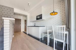 a kitchen and dining room with white brick walls at Apartamenty Sun & Snow Osiedle Pogodne in Kołobrzeg