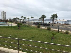 a park next to a beach with palm trees at Departamento Costa Peñuelas in Coquimbo