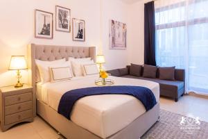 a bedroom with a large bed and a couch at Westminster Claren Tower - Downtown in Dubai