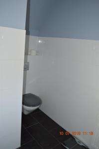 uma casa de banho com WC e piso em azulejo preto em Ferienwohnung Pitz em Saarbrücken