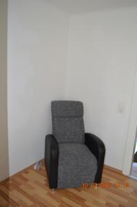 uma cadeira sentada num canto num quarto em Ferienwohnung Pitz em Saarbrücken