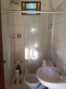 een badkamer met een douche, een wastafel en een toilet bij POUSADA ESTAÇÃO MARMELO in Queimada