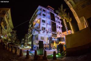a lit up building on a city street at night at El Mena Beach in Ras El Bar