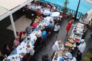 grupa ludzi siedząca przy stołach w restauracji w obiekcie Diogenis Blue Palace w mieście Guwes