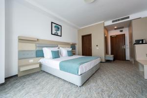 una camera con un grande letto in una camera d'albergo di Hotel Manor a Mamaia Nord - Năvodari
