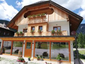 una casa en las montañas con ventanas y plantas en Affittacamere Krajnc, en Valbruna