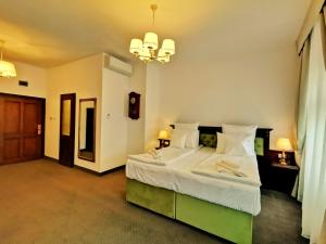a bedroom with a large bed and a chandelier at Casa Kuhn in Sighişoara