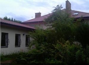 a white house with windows and a roof at Green Country Hostel in Piaseczno
