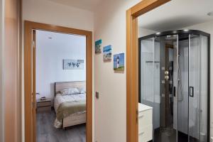 a bedroom with a bed and a glass shower at Appartement 1-4 pers - Proche Paris, CDG, Grand Paris Arena - A L'Ombre du Pin "5" in Le Pin