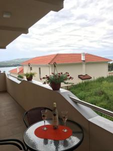 a table with two glasses and a bottle of wine on a balcony at ID apartments in Tivat