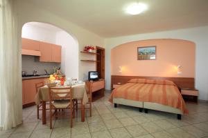 1 dormitorio con cama, mesa y cocina en Residence Giardino del Sole, en Isquia
