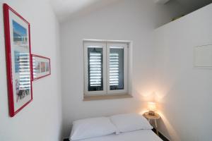 a white room with a bed and a window at Studio apartment Matoni in Postira