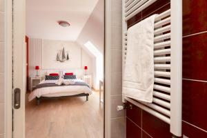 a bedroom with a bed with red pillows at Les Vestiges du jour in Clohars-Fouesnant