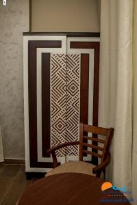 a wooden door with a chair next to a curtain at El Mena Beach in Ras El Bar