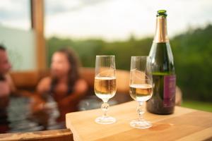 due bicchieri di vino bianco accanto a una bottiglia di vino di Le Hameau Des Sens a Phalsbourg