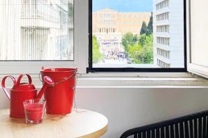 a table with two red containers and a window at CosmosDome. Best view in the heart of Athens! in Athens