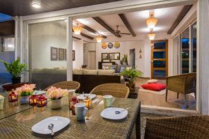 jadalnia ze stołem i krzesłami oraz salon w obiekcie EL Lodge by StayVista - Pool, lawn, and a charming gazebo for your perfect getaway w mieście Lonavla