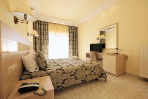 a hotel room with a bed and a desk and a window at Hotel Diamantidis in Myrina