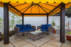 einen Pavillon mit blauen Stühlen und einem Tisch in der Unterkunft EL Lodge by StayVista - Pool, lawn, and a charming gazebo for your perfect getaway in Lonavla