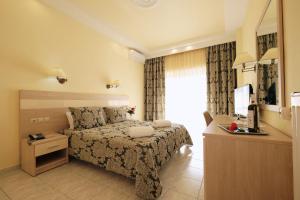 a bedroom with a bed and a dresser and a television at Hotel Diamantidis in Myrina