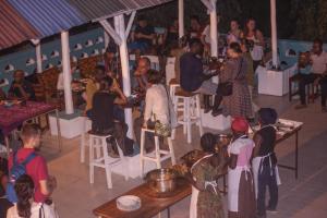 een groep mensen die aan tafel zitten in een restaurant bij Cefa Hostel in Dar es Salaam