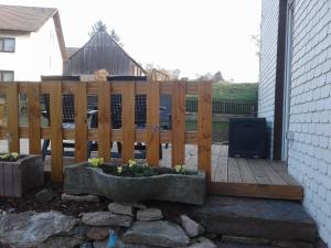 a patio with a wooden fence and some plants at Kreuzdellenhof _ Ferienwohnung in Hembach