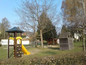a playground with a slide and a play structure at Kreuzdellenhof _ Ferienwohnung in Hembach