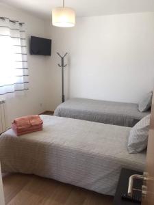 a room with two beds and a tv on the wall at Casa Luna in Pataias