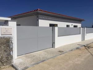 a white fence in front of a white house at Casa Luna in Pataias