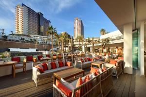 a row of tables with chairs and umbrellas at Hard Rock Hotel Tenerife in Adeje