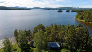 an aerial view of a lake with a house at Strandgården i Åredalen, stugor in Mörsil