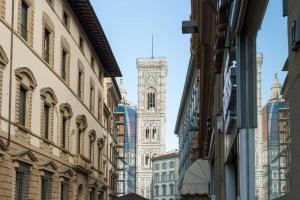a city street with a clock tower in the distance at DUOMO SUITE GHIRLANDAIO in Florence