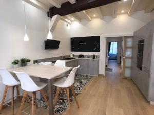 a kitchen with a wooden table and white chairs at Appartement de charme classé 4 étoiles coeur historique de Dinan in Dinan