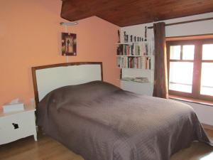 1 dormitorio con cama, ventana y estante para libros en la cle des champs, en Saou