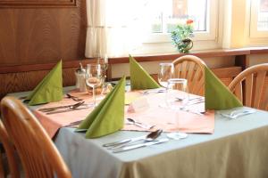 a table with green napkins and wine glasses on it at Gasthof Pension „Zur Hammerschmiede“ in Drosendorf Altstadt