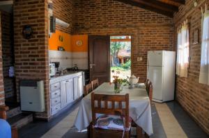 uma cozinha com uma mesa e um frigorífico branco em El Rodeo Apart Cabañas em Santa Rosa de Calamuchita